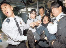 Korean police dragging away a female protestor