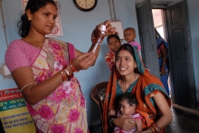 Health worker in India prepares to vaccinate baby