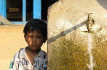 Enfant à côté d'un point d'eau au Nepal, photo par niOS